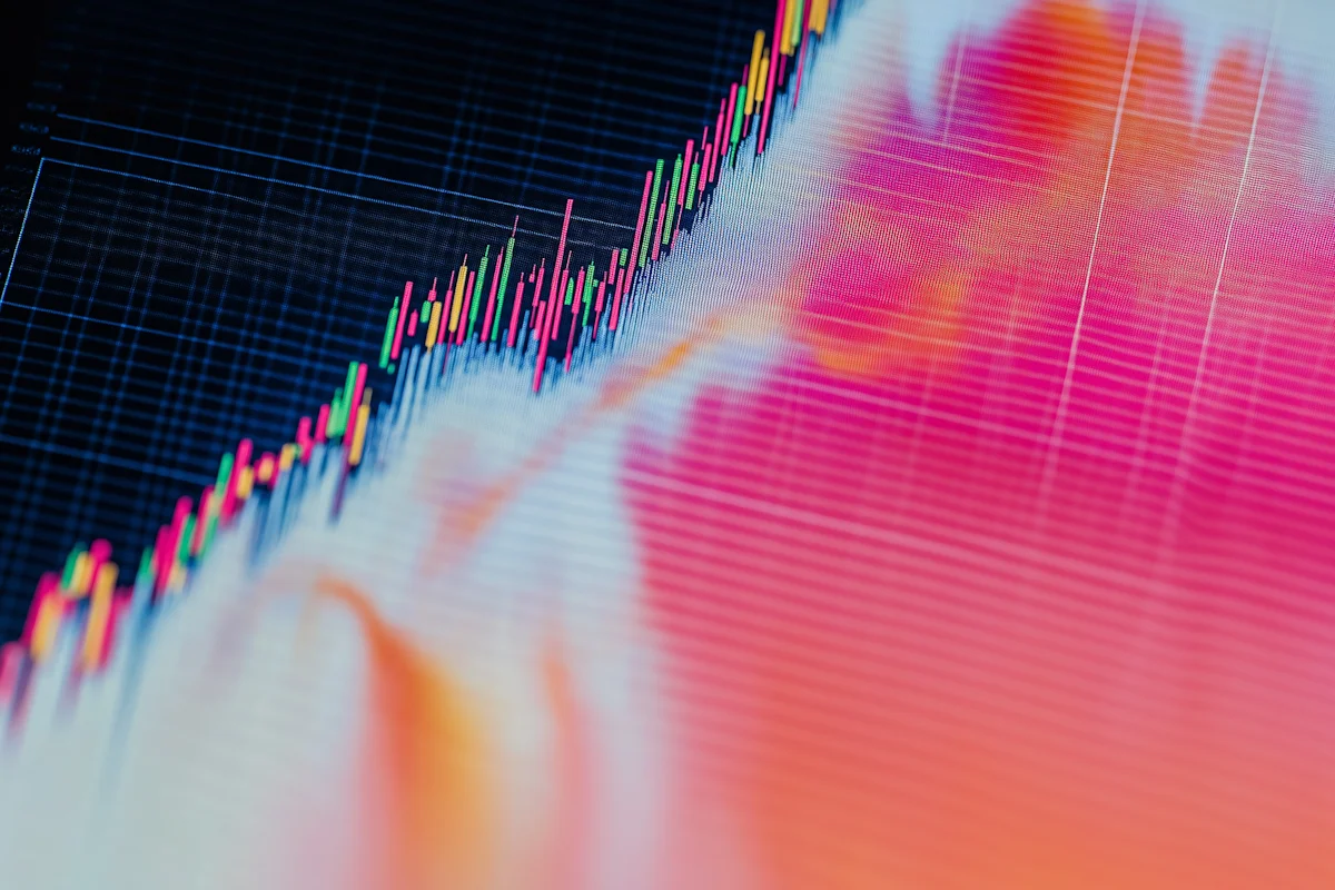 Professional financial analyst reviewing market data and charts on multiple monitors